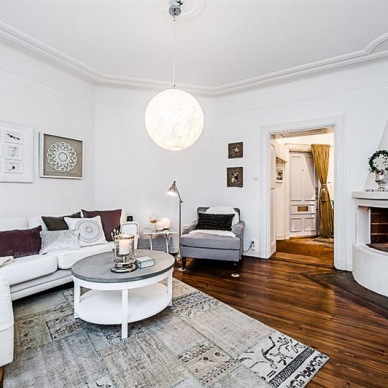 Białe skandynawskie mieszkanie o nieregularnym kształcie z cudowną podłogą z ciemnego drewna!