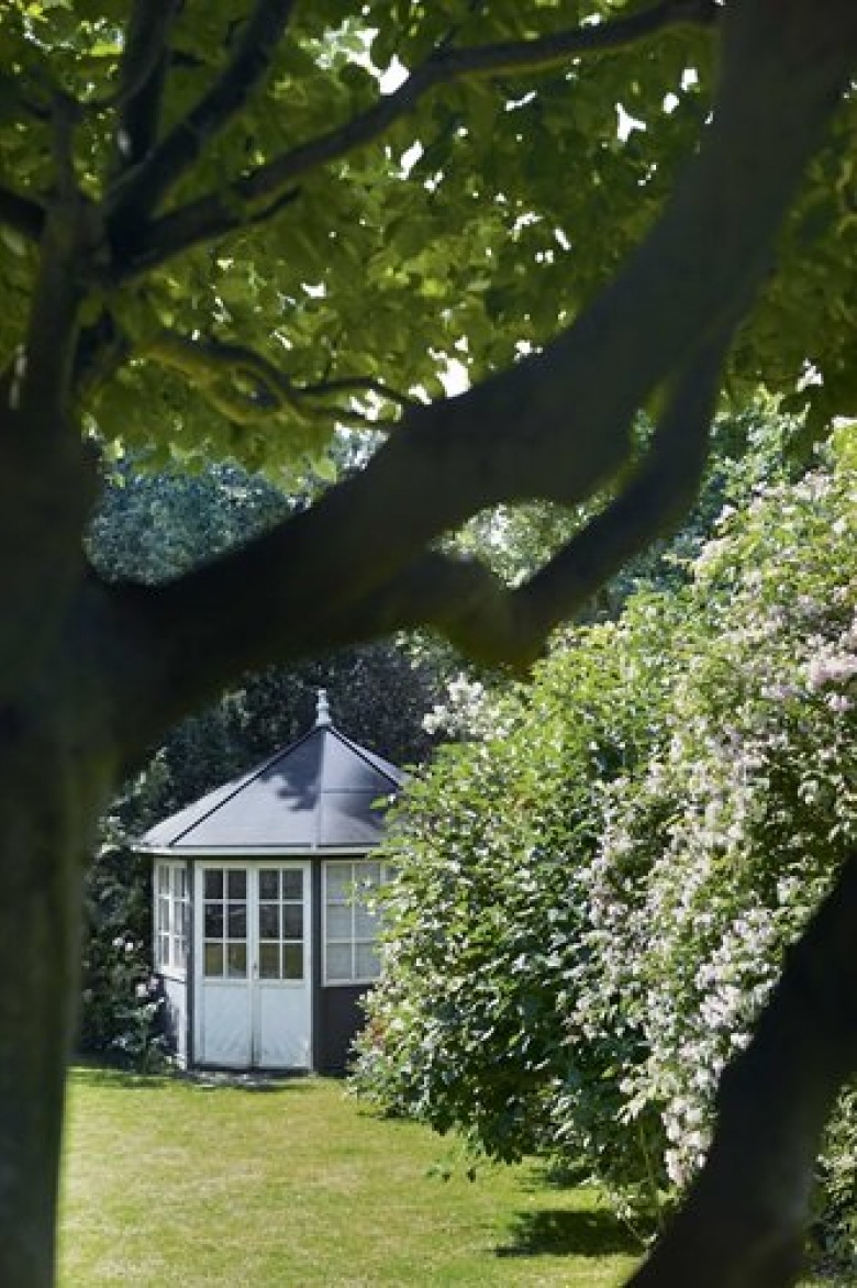 Zielony ogród ze starodrzewiem, i mały okragły domek letni w ogrodzie przy domu (26201)