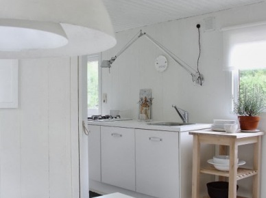 Drewniany pomocnik wyspa w bialej minimalistycznej kuchni z długim kinkietem (21575)