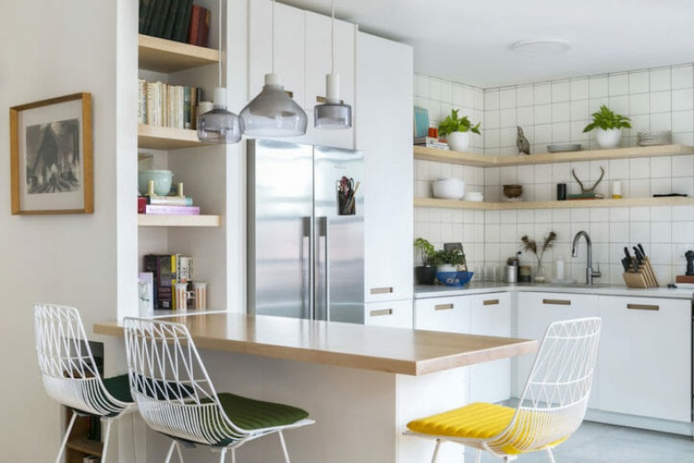 Białe szafki rozświetlają kuchnię, podobnie jak dobrane do nich dodatki. Wszystkie meble oraz wystawione na widoku akcesoria mają prostą formę, która idealnie podkreśla skandynawski styl w...