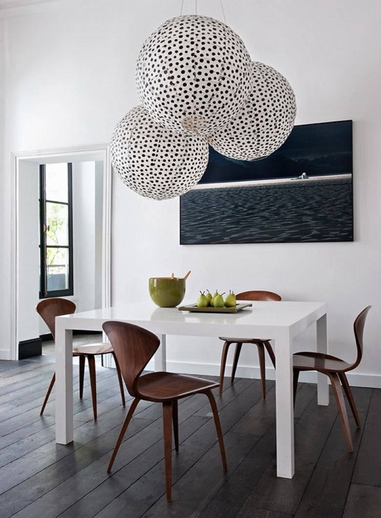 Ciemno-szara deska na podlodze,biale ściany,biały nowoczesny stół  z brązowymi krzesłami,nowoczesny obraz i papierowe kule lampiony w czarne kropki w jadalni (26187)