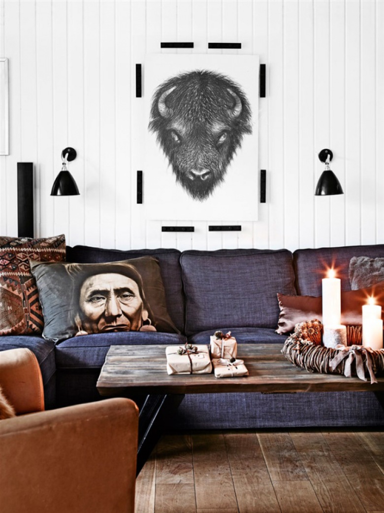 Skandynawskie grafiki,czarne kinkiety na białej ścianie nad szarą sofą z etnicznymi poduszkami (27691)