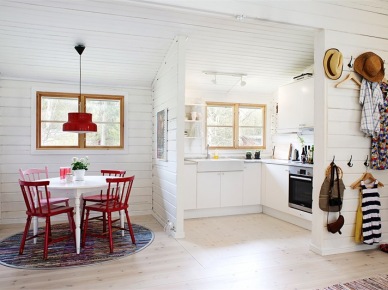 Mała biała kuchnia z jadalnią z okrągłym stołem i czerwonymi krzesłami z drewna (23777)
