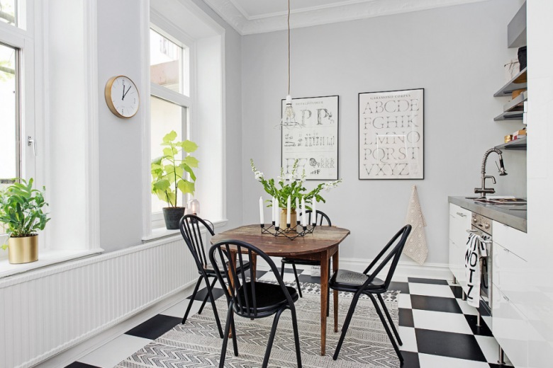 Posadzka ułożona w szachownicę,tkany dywan skandynawski z etnicznym wzorem,czarne krzesła przy drewnianym brązowym stole (28576)