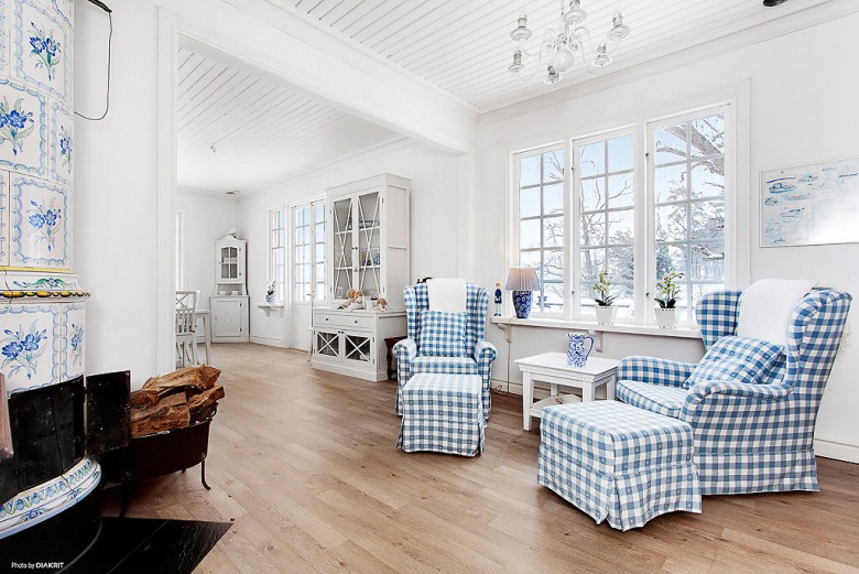 Otwarta przestrzeń jadalni z pokojem wypoczynkowym ze stylowym biało-niebieskim  kominkiem (21956)