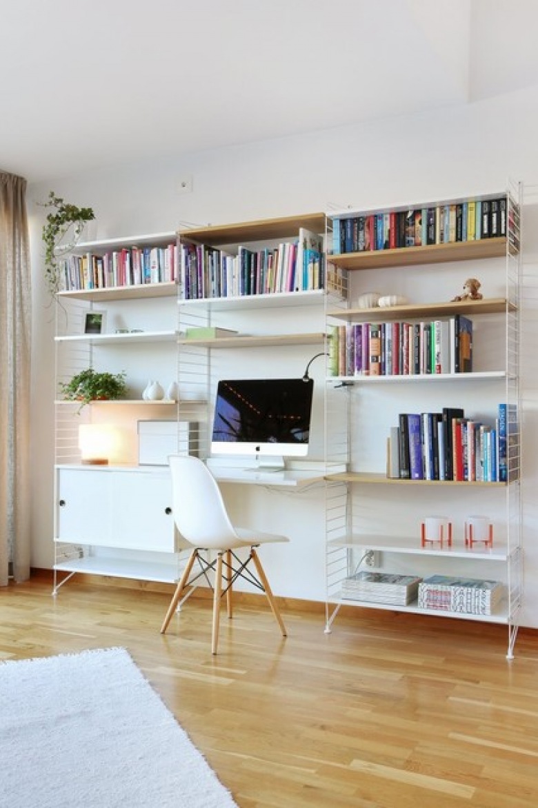 Przestronny pokój biurowy urządzono w skandynawskim stylu. Drewniana podłoga pięknie koresponduje z wiszącymi półkami. Lekkie krzesło i blat biurka idealnie wpisują się w kompozycję...