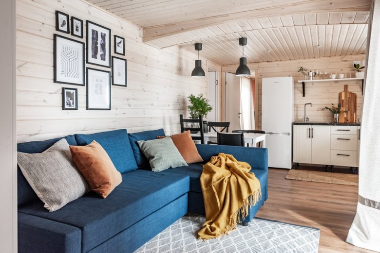 Niebieska sofa w małym pokoju dziennym to element, który przykuwa do siebie uwagę. Zdecydowany kolor współgra z prostym kształtem, dzięki czemu aranżacja salonu jest wyważona i...