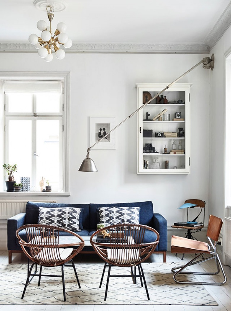 Salon w stylu vintage z ażurowymi drewnianymi fotelami, granatową sofą i kinkietem na wysięgniku (48327)