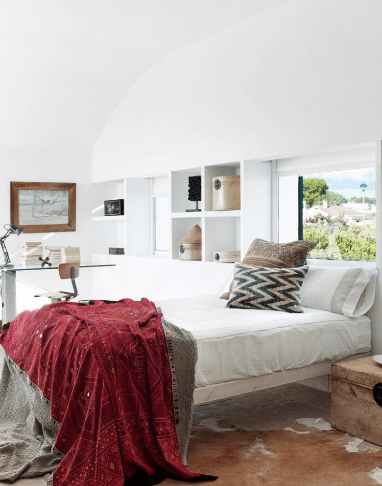 Murowane wapienne półki,drewniane lustro i łóżko,drewniana skrzynia i dywan ze skóry bydlęcej w aranżacji sypialni (25607)