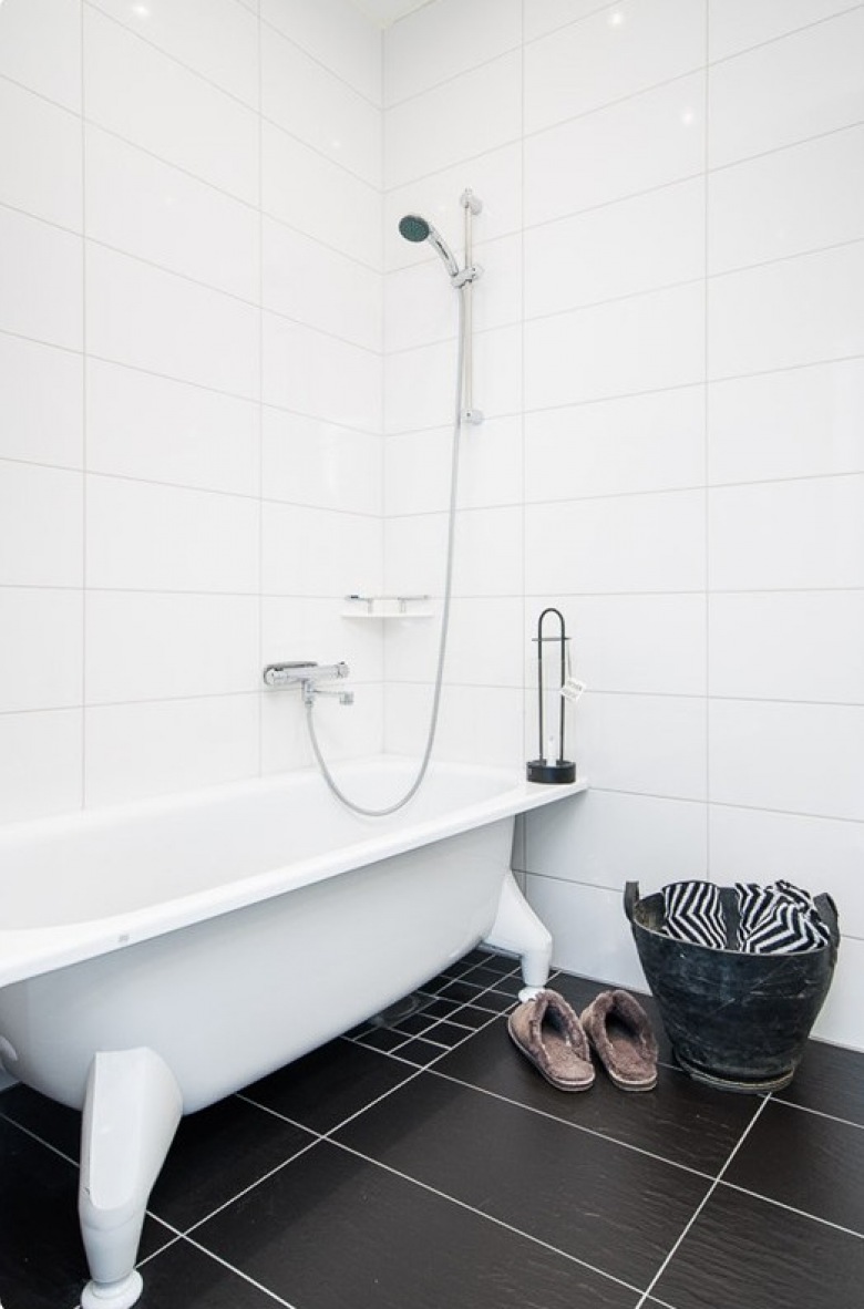 Aranżacja białej łazienki z wanną na łapkach i czarną terakotą na podłodze (21978)