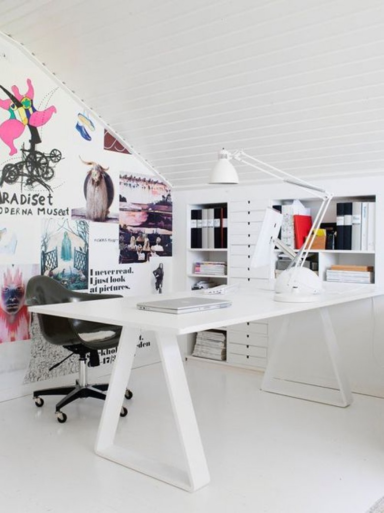 Białe biurko nowoczesne,biała lampa na biurku,biała zabudowa z pólkami i szufladami pod skośnym dachem i pomysłowa ściana z naklejonymi plakatami i napisami (26155)