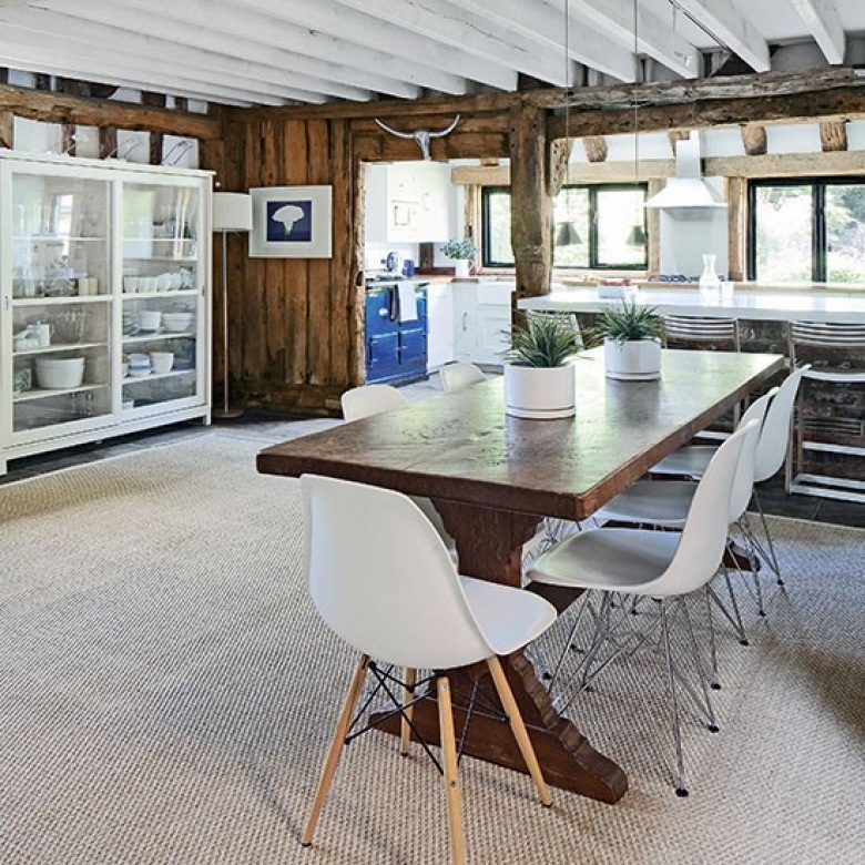 Drewniany wiejski stół,białe nowoczesne krzesła,przeszklona witryna i  deski na ścianach w  wiejskiej  kuchni z jadalnią (22873)