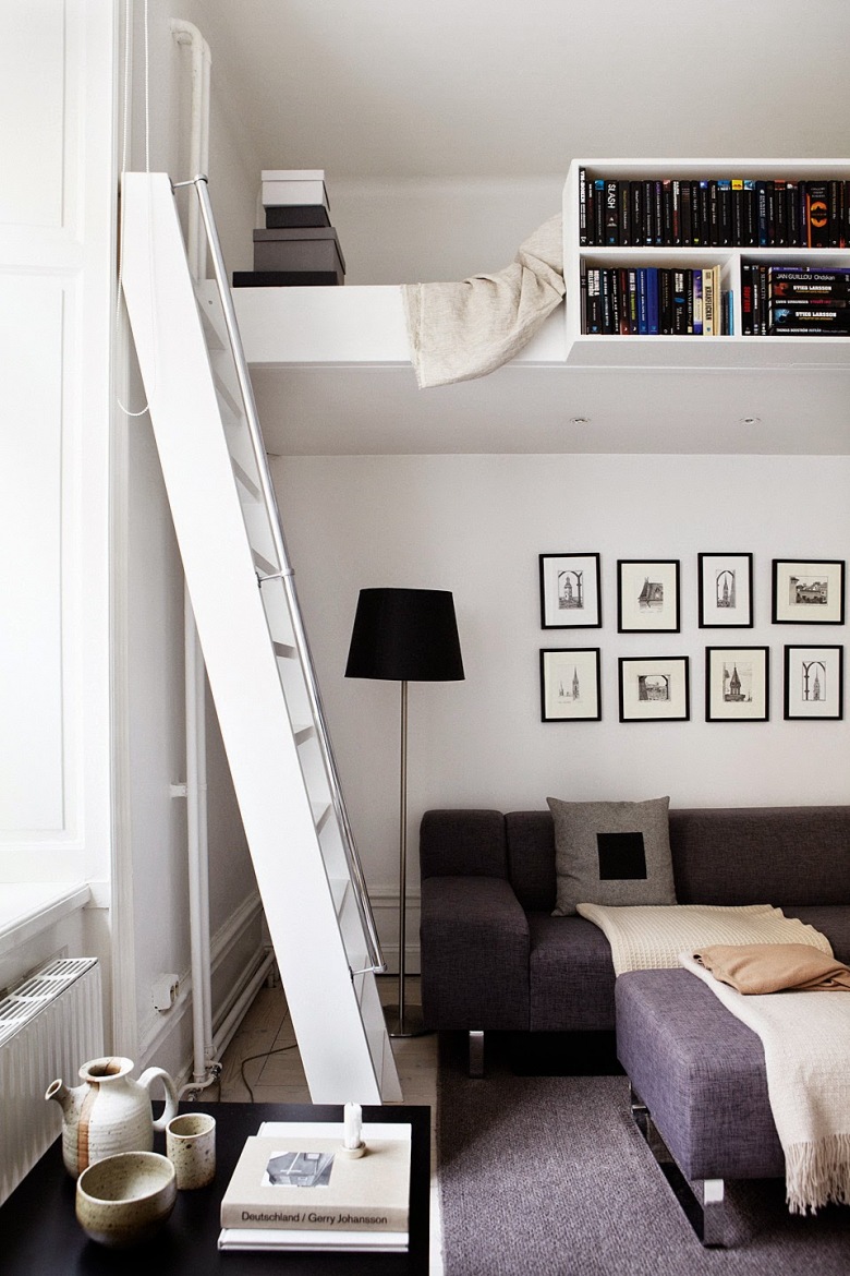 Mini antresola z półkami na książki i białą drabiną nad grafitową sofą w salonie (27649)