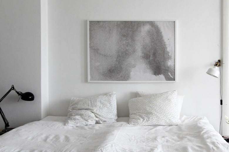 Czarna lampka biurkowa i biały kinkiet przy łóżku w minimalistycznej sypialni (25452)