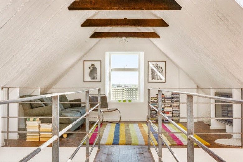 Drewniane belki przy skosnym suficie,dywan w kolorowe pasy,drewniana balustrada przy schodach (28623)