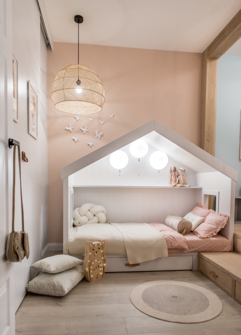 W pokoju dziecięcym znajduje się bardzo ciekawe oświetlenie. W łóżku, które przypomina domek, wiszą trzy lampy w kształcie baloników. To podkreśla przytulny charakter...
