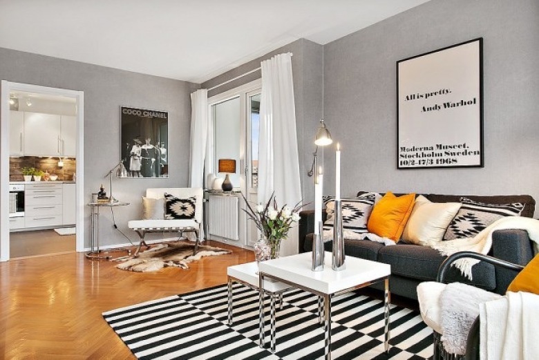 Nowoczesny biało-szary salon skandynawski z zółtymi i biało-czarnymi etnicznymi poduszkami na grafitowej sofie (27515)