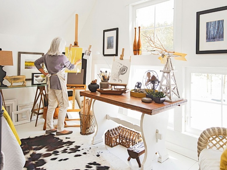 Domowa pracownia w wiejskim stylu z rustykalnym stolem na profilowanej białej podstawie,wikinowe i drewniane pojemniki,dywan biało-czarny z bydlęcej skóry,dekoracyjne gałązki i biały lampion na stole (26164)