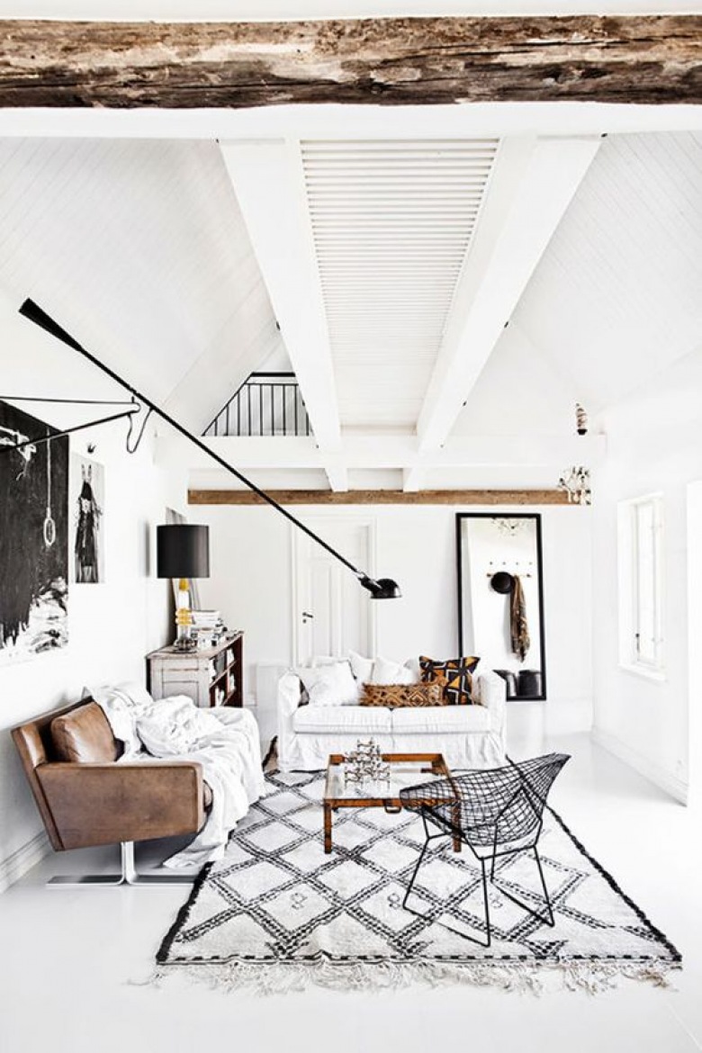 Drewno i biel stanowią klasyczny zestaw skandynawskiej aranżacji. Belki pod sufitem oraz skórzana sofa w znaczący sposób urozmaicają jasną przestrzeń. Delikatny dywan z geometrycznym wzorem podobnie dekoruje...