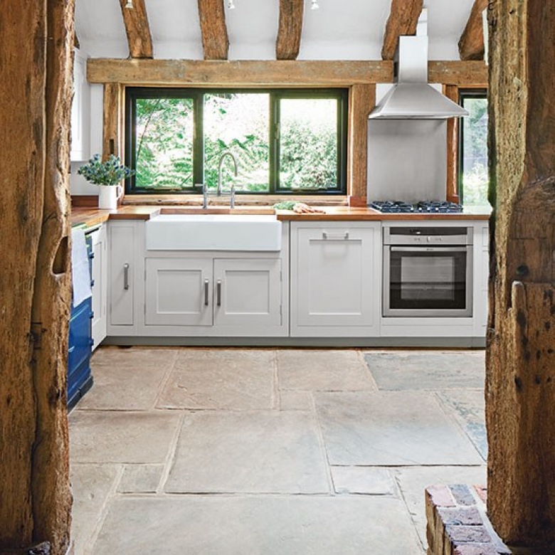 Skandynawska kuchnia w aranżacji wiejskiej kuchni z drewnianymi belkami i kamienną podłogą (22870)