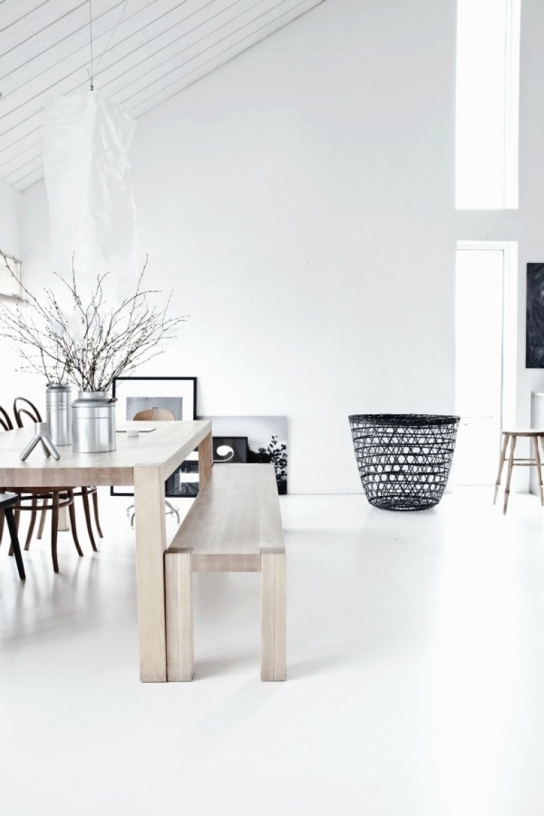 Biały salon, drewniany stół w naturalnym kolorze i ażurowy czarny kosz (20772)