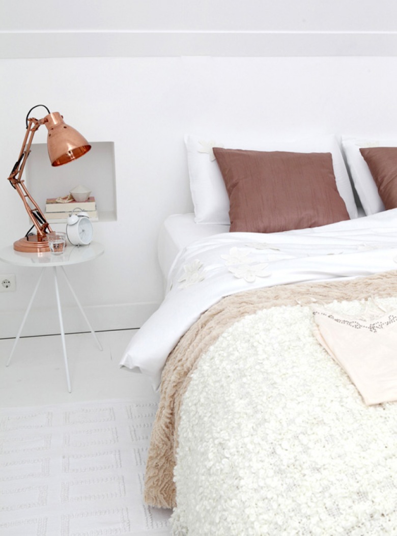 Miedziana lampka i miedziany kolor poduszek w aranżacji białej sypialni (22886)