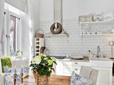 Wiklina,drewniany stół i wiszące białe półki w skandynawskiej kuchni (24385)