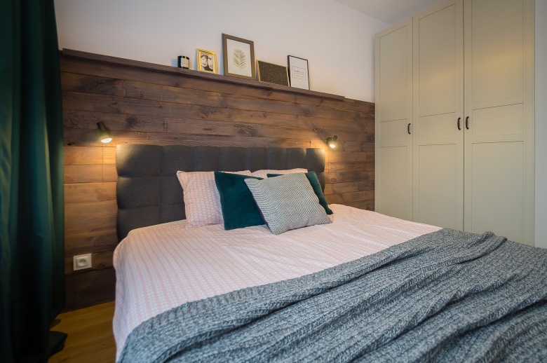 Polska aranżacja przytulnego mieszkania z otwartą kuchnią i drewnianą ścianą w sypialni (54970)