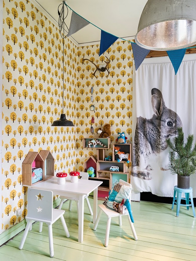 Miętowy kolor desek na podłodze w pokoju dziecięcym, z tapetą w żółto-czarne drzewka,niebieskimi proporczykami i zasłonami z królikami (27529)