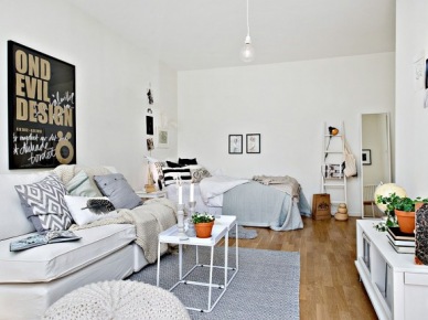 Łóżko w salonie,drewniana biała drabinka,biała sofa,białe stoliki kawowe z tacą i czarne plakaty na ścianie (24696)