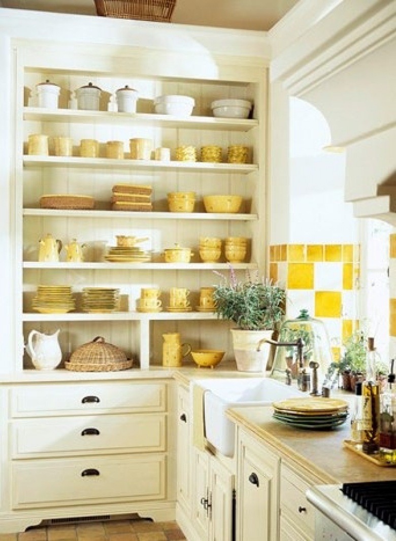 Biało-żółte płytki na ścianie i żółta zastawa stołowa w tradycyjnej kuchni (22259)