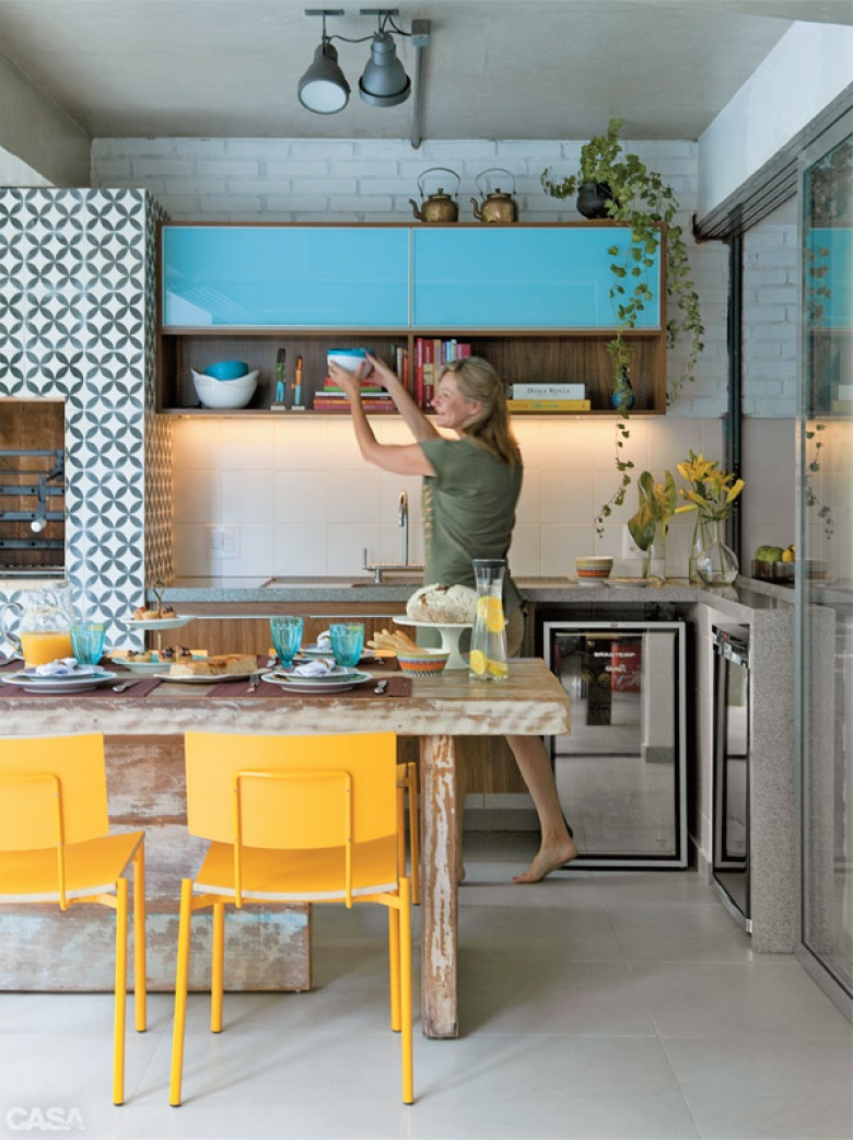 Niebieskie szafki w kuchni w połączeniu zdrewnem i żółtymi krzesłami w jadalni (28467)