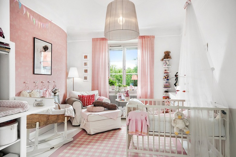 Różowa tapeta ścienna,biało-różowy dywanik w kratkę,różowe lekkie zasłony i białe meble w pokoju dziecięcym (26711)