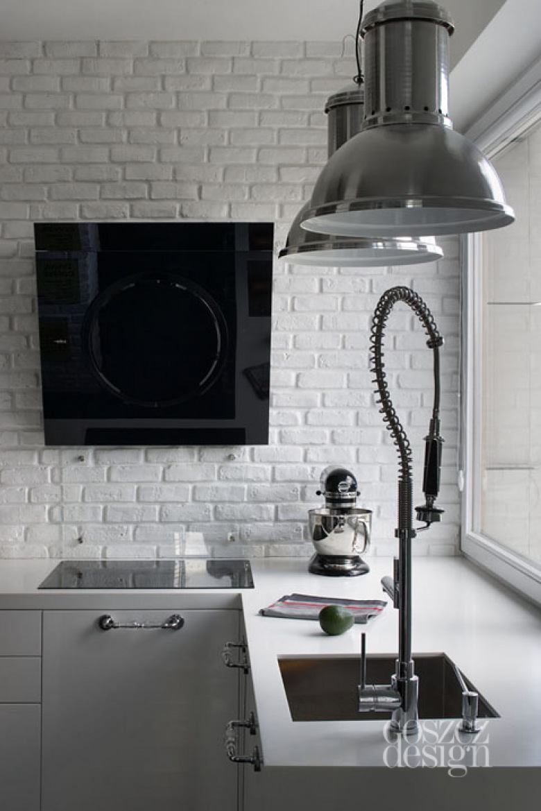 Biała cegła na ścianie,szare lampy pendant i nowoczesny okap w kuchni (24115)