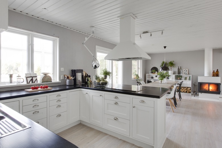 Biały okap nad czarną ladą kuchenną w otwartej na salon kuchni skandynawskiej (27118)