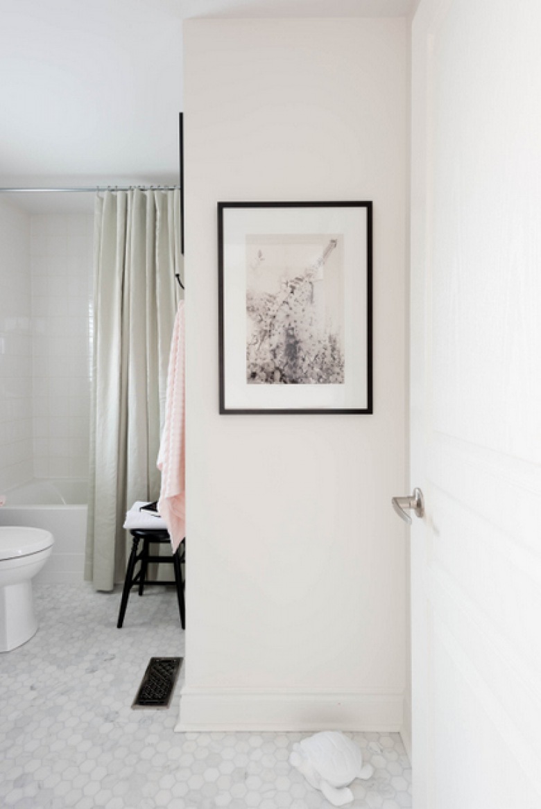 Na wejściu do łazienki pojawia się schludna przestrzeń, którą upiększają drobne dodatki. Obraz w czarnej ramce albo zabawny ozdobny żółw w białym kolorze, który stoi na podłodze, stanowią ciekawą dekorację...