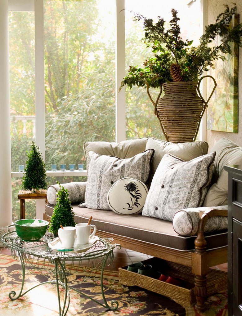 Wyplatany wazon z bukietami,kuty turkusowy stolik pomocniczy,stylowa drewniana kanapa z poduchami i zielone małe choinki świąteczne (27405)