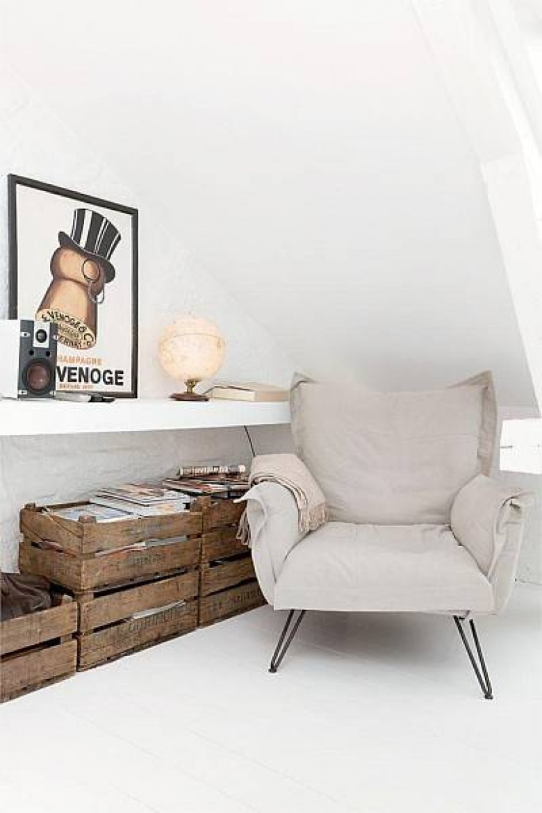 Nowoczesny fotel z poduchami z bawełny, drewniane skrzynki,murowanan wapienna półka i nowoczesny plakat na białej ścianie (26168)