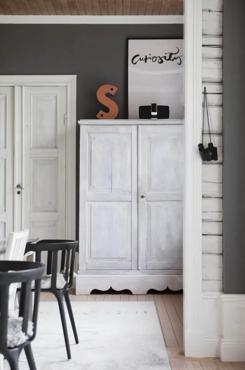 Czarne ściany z białymi listwami,drewniany dufit,bielone przecierane szafy i czarnegiete  krzesła skandynawskie (25995)
