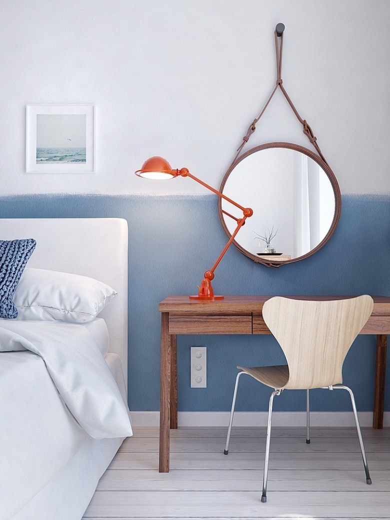 Okrągłe lustro skandynawskiw,czerwona lampka przy łóżku,biało-niebieska ściana i drewniany stolik w sypialni (24813)