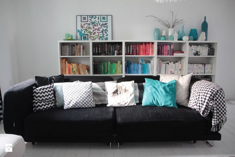 Czarna kanapa z dekoracyjnymi poduszkami w nowoczesnym salonie (49715)