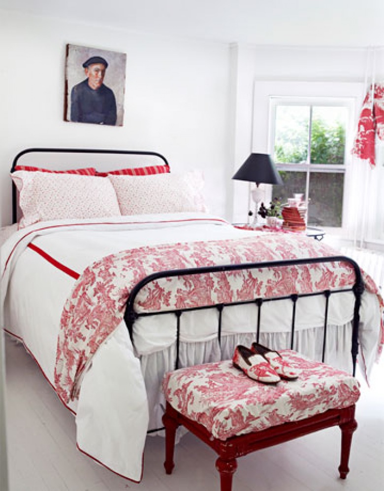 Czarne kute łóżko,czerwony puf i stylowa biało-czerwona pościel w wiejskiej sypialni (24399)