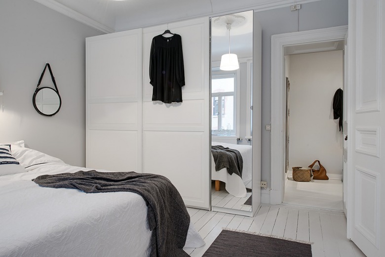 Biała szafa z lutrzanymi drzwiami w skandynawskiej sypialni (21619)
