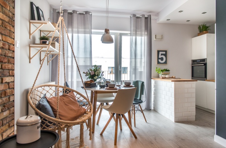 Białe meble w kuchni oraz drewniane elementy w całym wnętrzu podkreślają klimat skandynawski, jednak cała otwarta przestrzeń zaaranżowana jest w stylu eklektycznym....