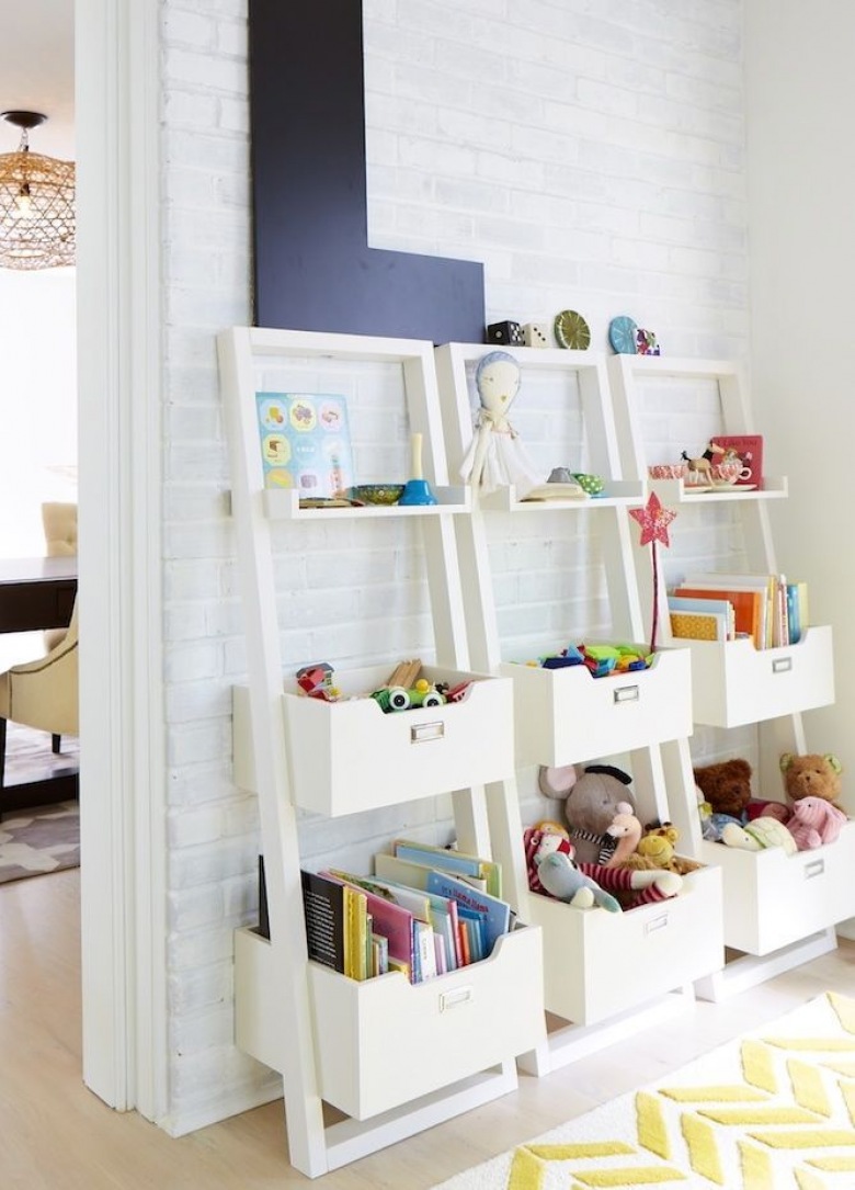 Białe drabinki z pojemnikami na dziecięce zabawki przy ścianie z białej cegły (26760)
