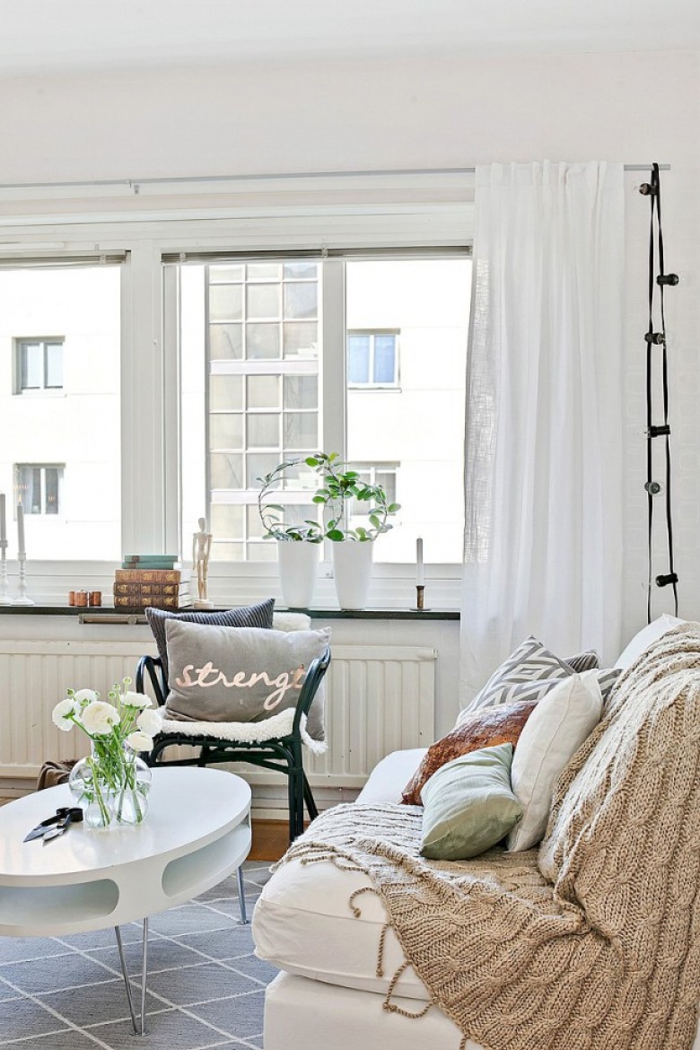 Beżowy dziergany koc,miętowa poduszka,białe zasłony,czarna girlanda z żarówek w salonie w stylu skandynawskim (28484)