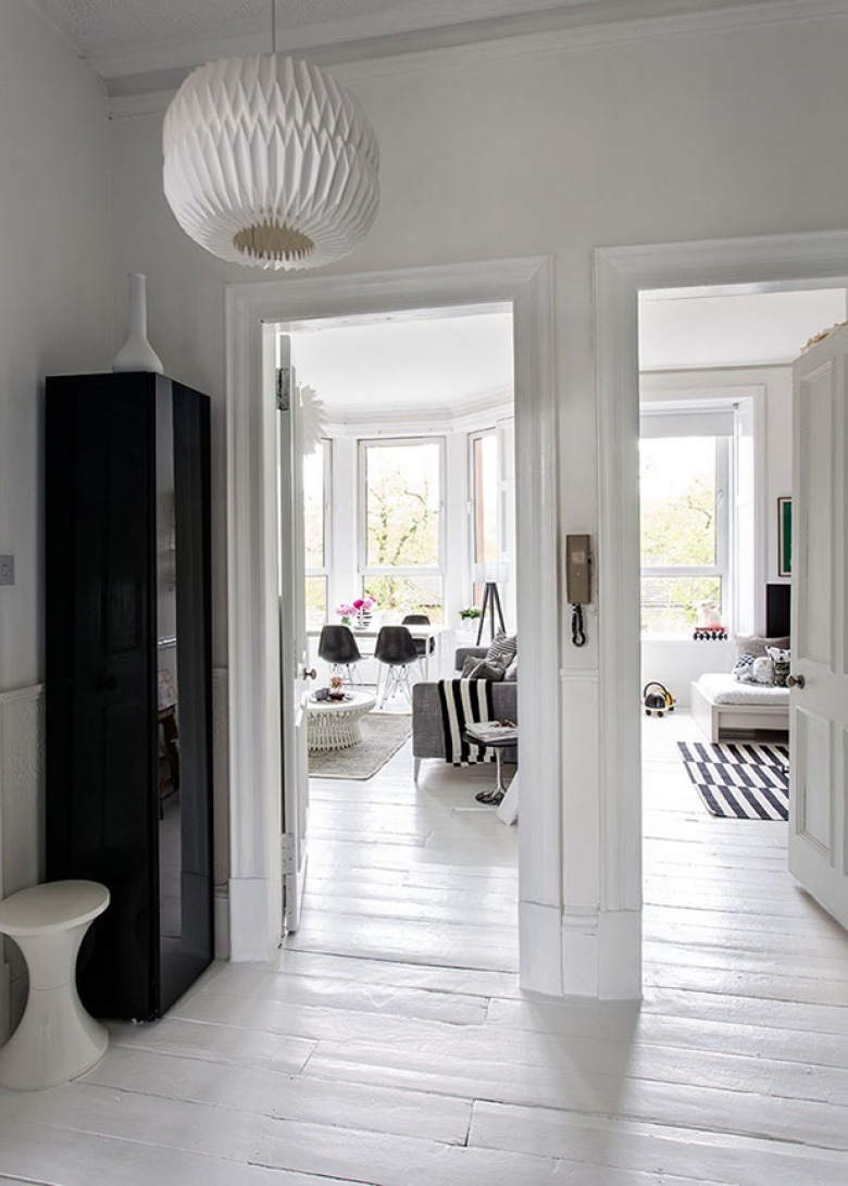 Biały pzredpokój z czarną szafą z widokiem na wnętrze mieszkania w stylu skandynawskim, (21549)