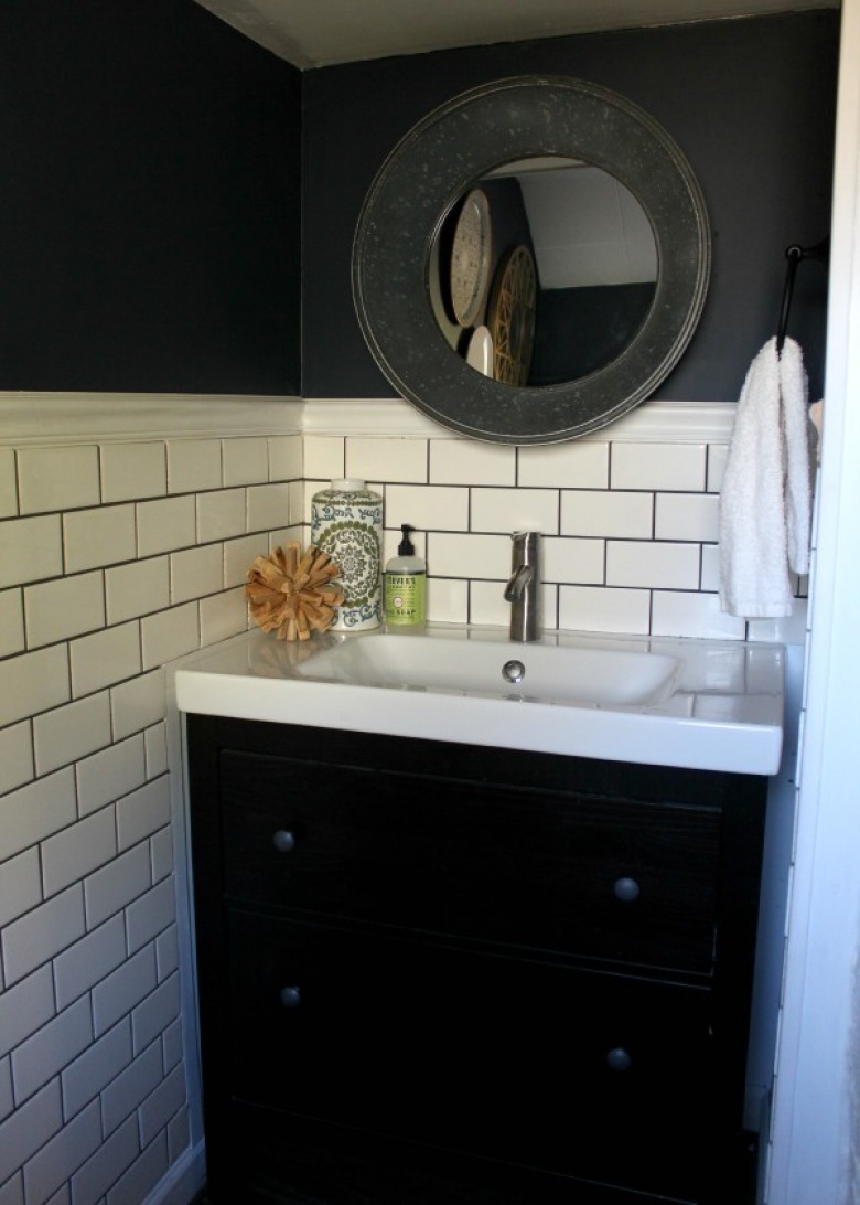 W małej łazienkowej wnęce umieszczono szafkę z umywalką. Mebel jest czarny, podobnie jak część ściany, co dodaje wnętrzu spójności i jednocześnie eleganckiego...