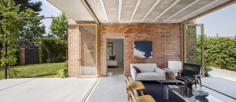 Przeszklony salon z czerwonej cegły z betonową posadzką i składanymi przesuwnymi ścianami ze szkła i drewna (22899)