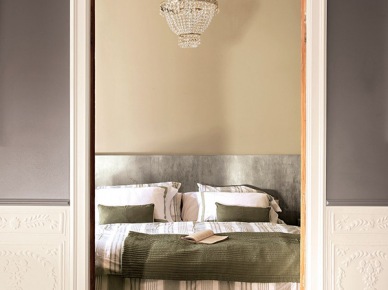 Szaro-beżowe ściany , kryształowy żyrandol i prosta dekoracja łóżka w sypialni (22188)